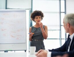 Kvinna presenterar en innehållsplan på whiteboard för kollegor